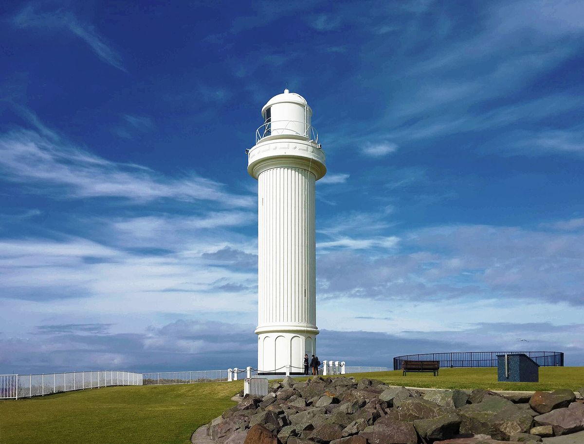 The white Flagstaff Point Lighthouse on Wollongong Head under a deep blue sky